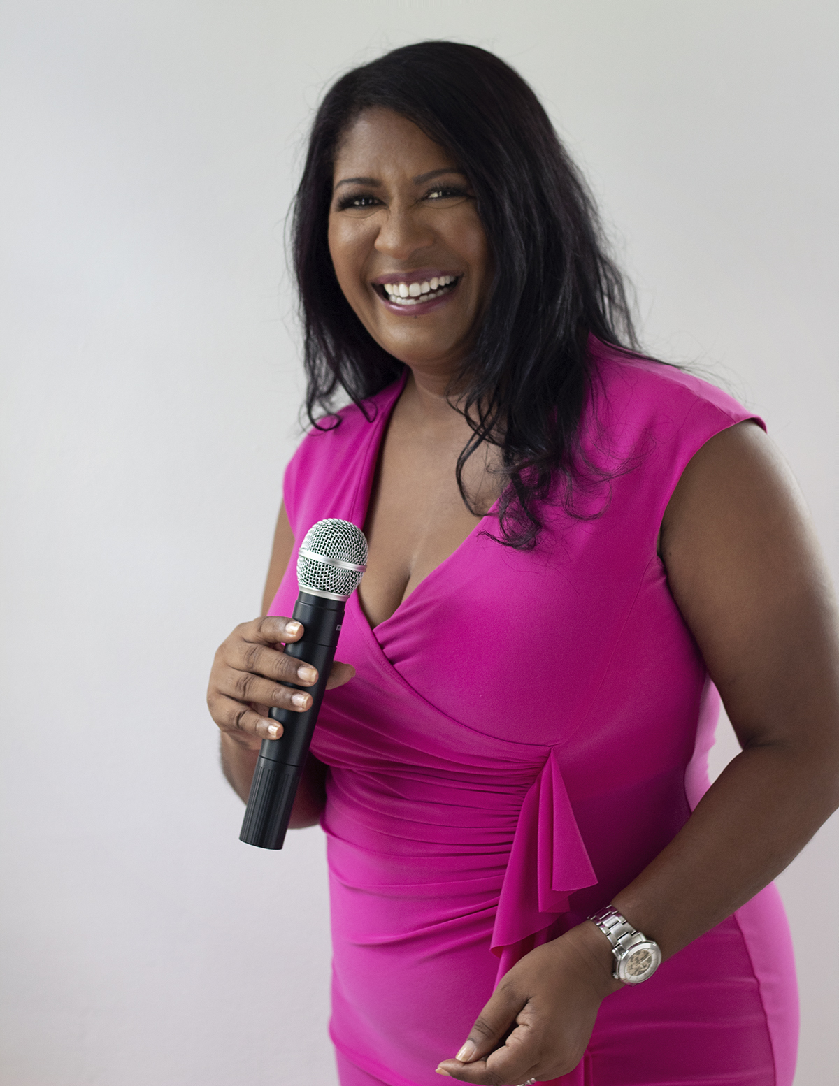 smiling woman holding and speaking into a microphone 